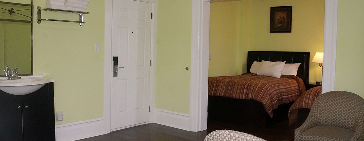 A hotel room with a bed, bathroom, and chair